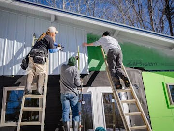 Construction Workers Adding New Siding to A Home